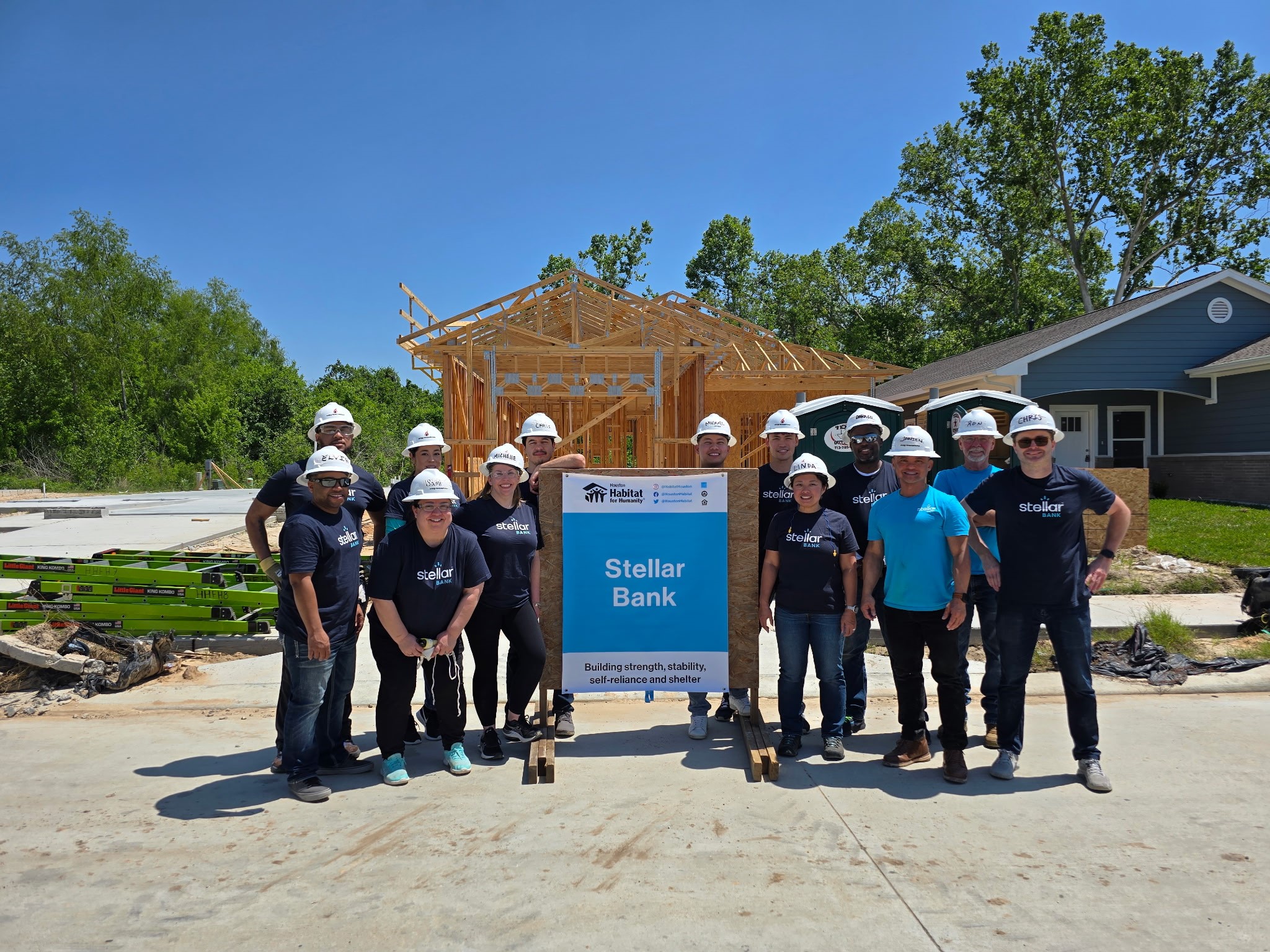 Stellar Bank employees standing in front of a home construction site for Houston Habitat for Humanity