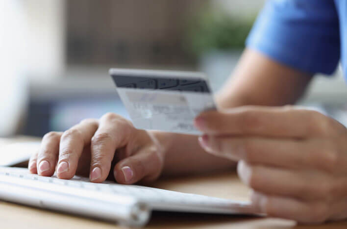 A man typing in credit card info on a keyboard